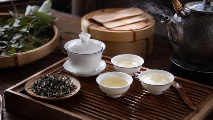 Chinese tea leaves, gaiwan, cups, and bamboo tea tray