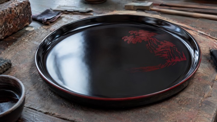 Glossy polished Chinese lacquer surface with craft tools in a workshop