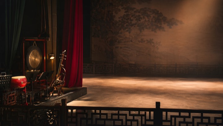 Peking opera stage with instruments and minimal props under warm stage light